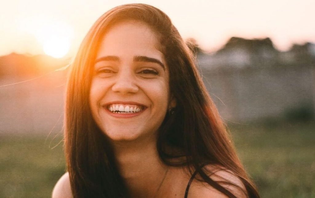 woman smiling at camera during sunset
